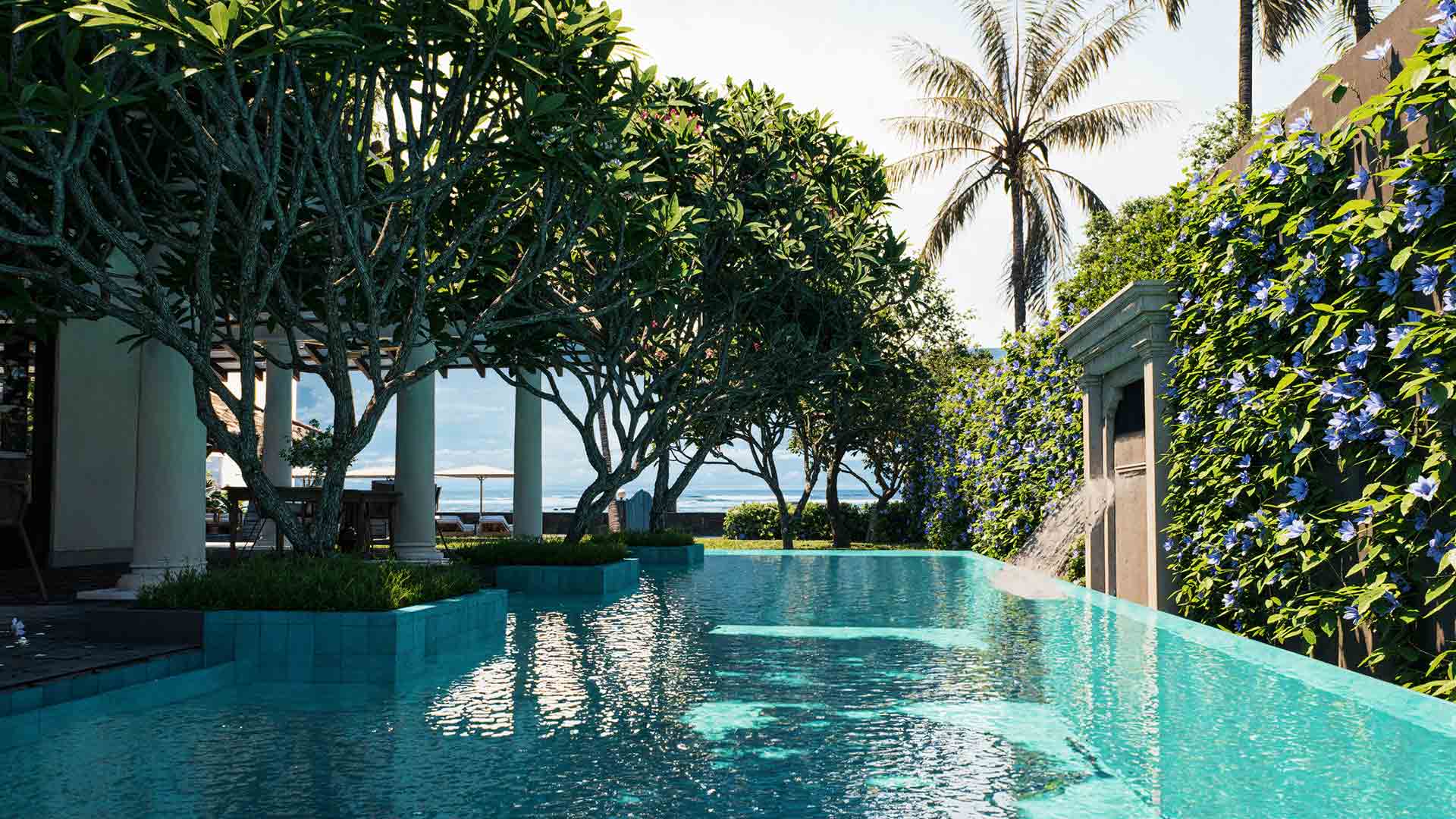 A serene pool lined with lush greenery at IF Villa